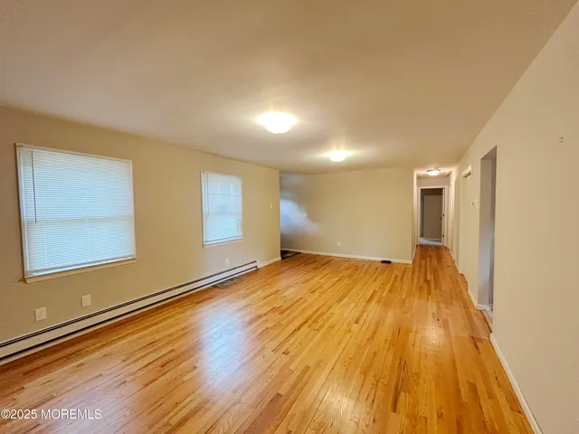 a view of empty room with wooden floor