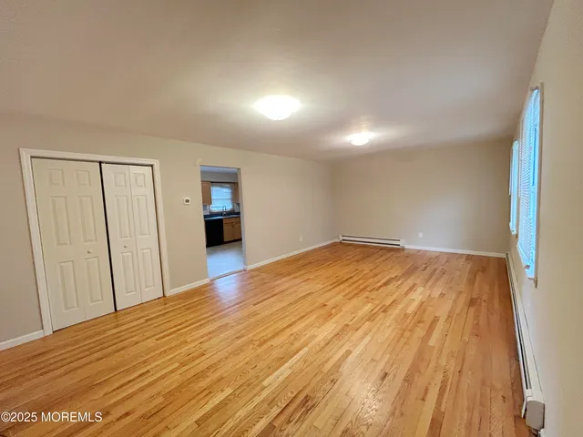 a view of empty room with wooden floor