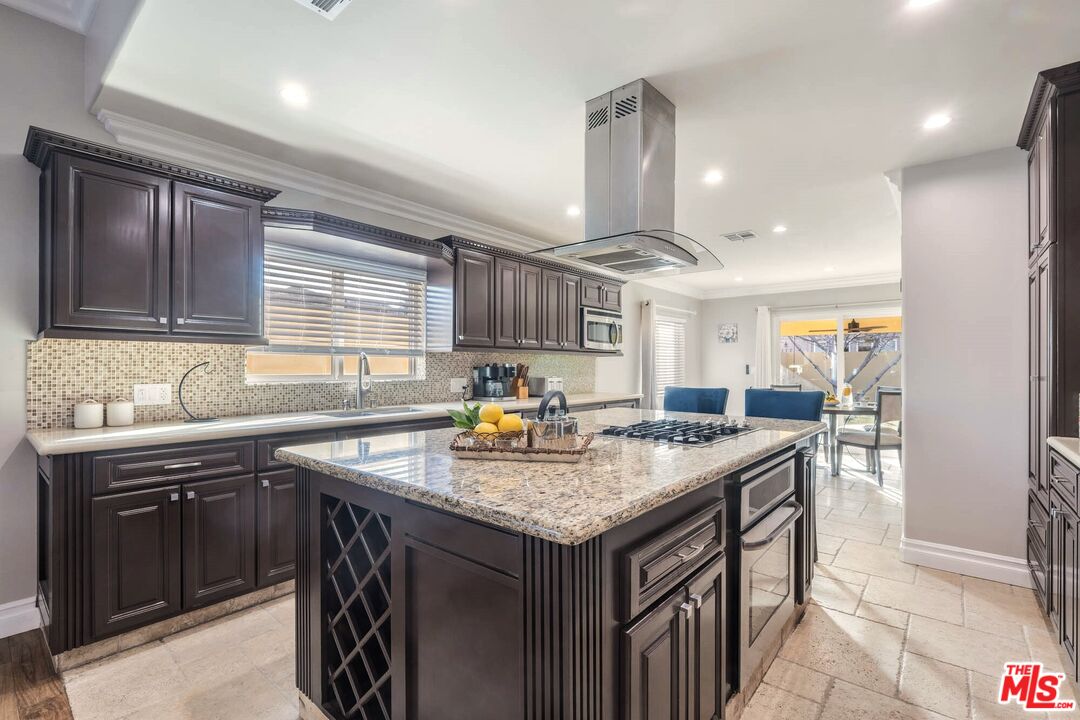 5181 Densmore Avenue Encino, CA 91436 - Photo 14 of 73 a kitchen with stainless steel appliances granite countertop a sink a stove and a wooden cabinets