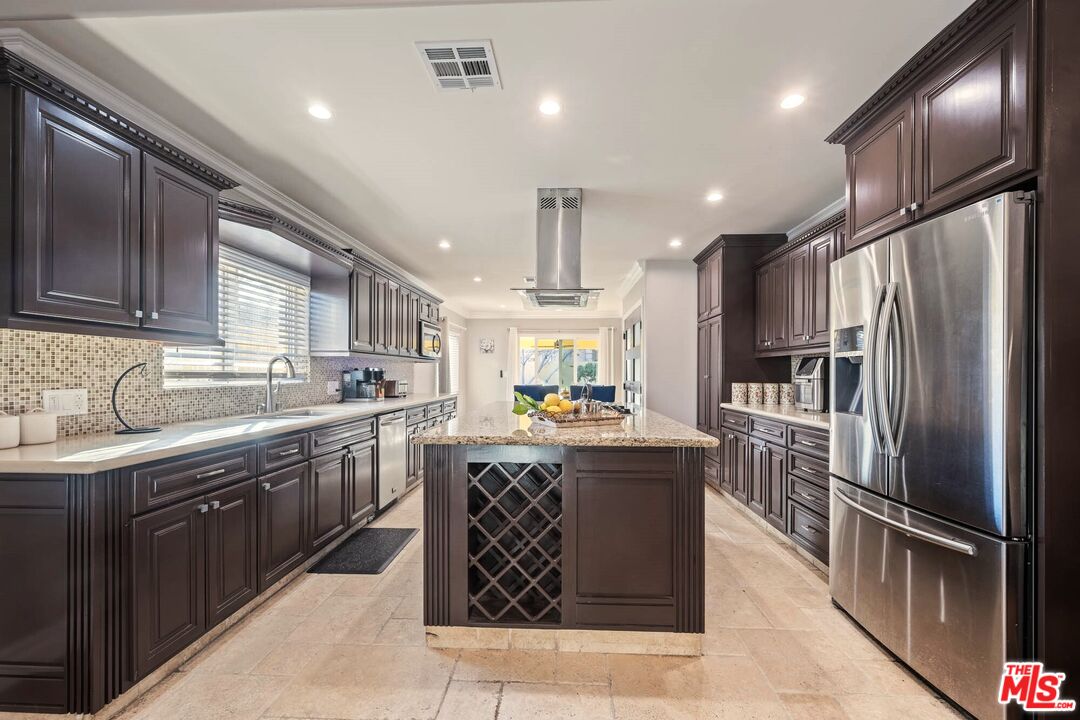 5181 Densmore Avenue Encino, CA 91436 - Photo 15 of 73 a kitchen with granite countertop stainless steel appliances a sink stove and refrigerator
