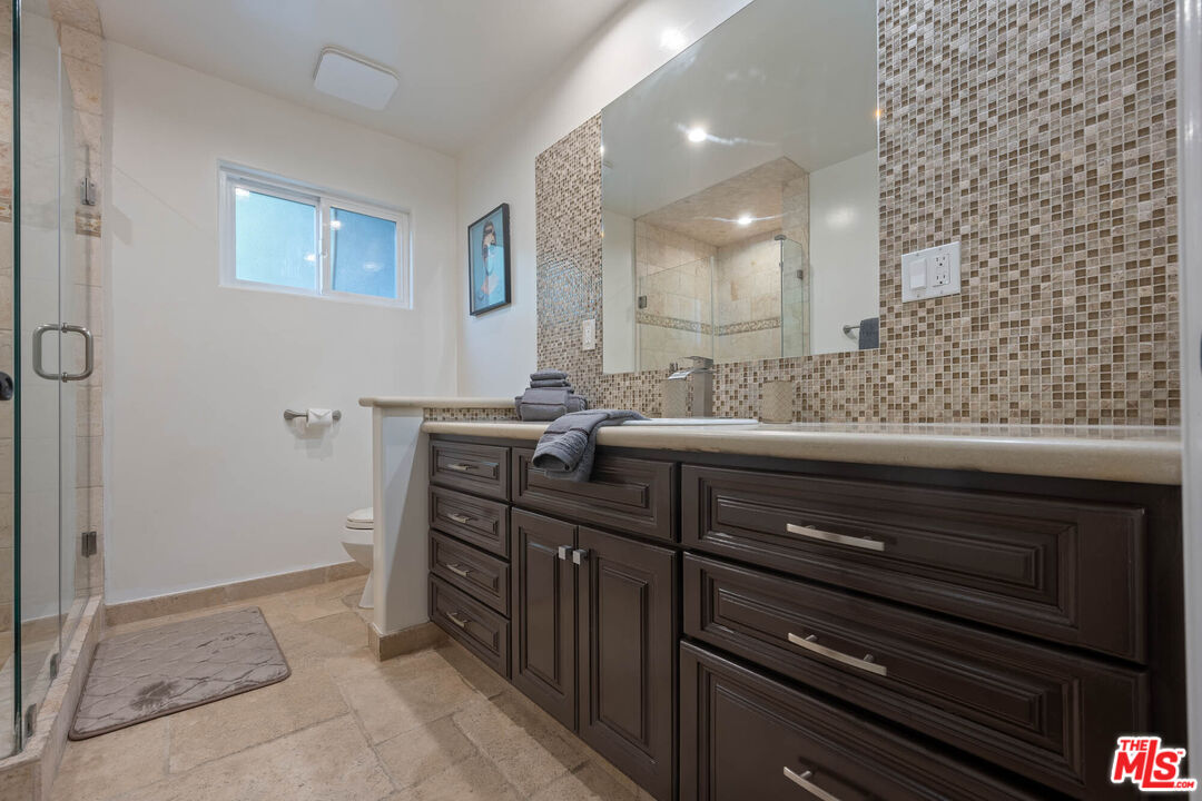 5181 Densmore Avenue Encino, CA 91436 - Photo 16 of 73 a room with a mirror and a sink