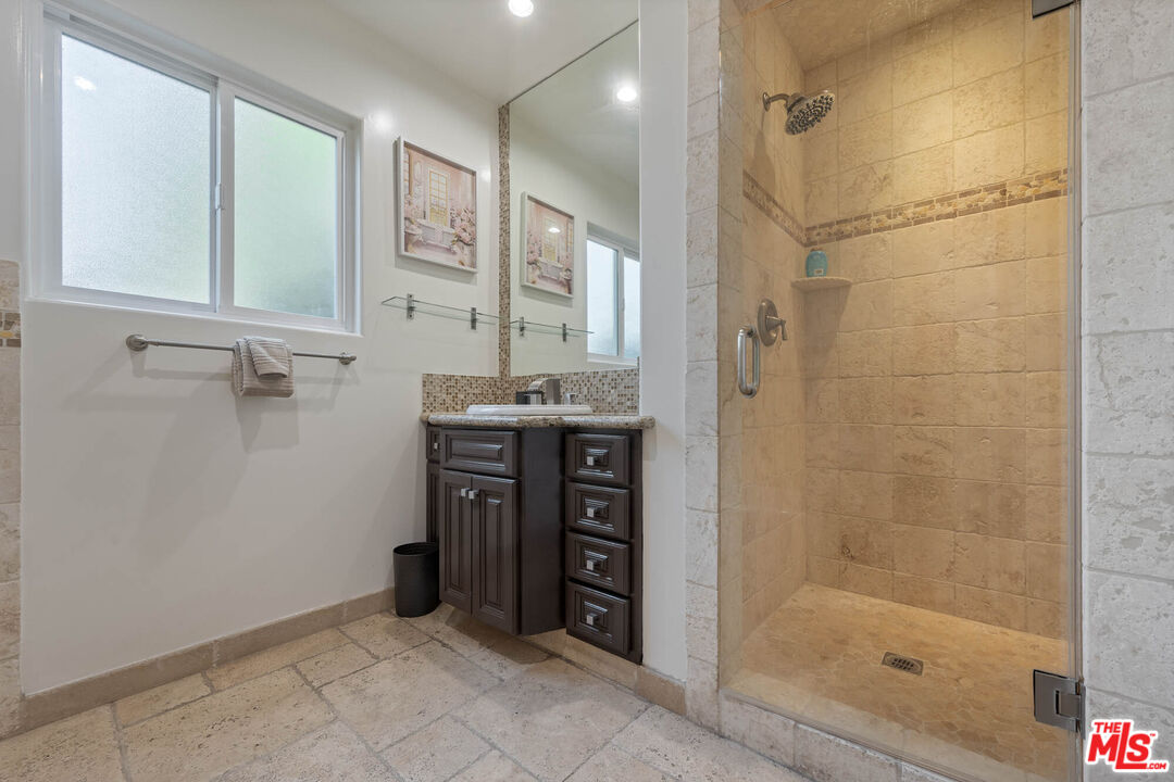 5181 Densmore Avenue Encino, CA 91436 - Photo 19 of 73 a bathroom with a shower a sink and a mirror