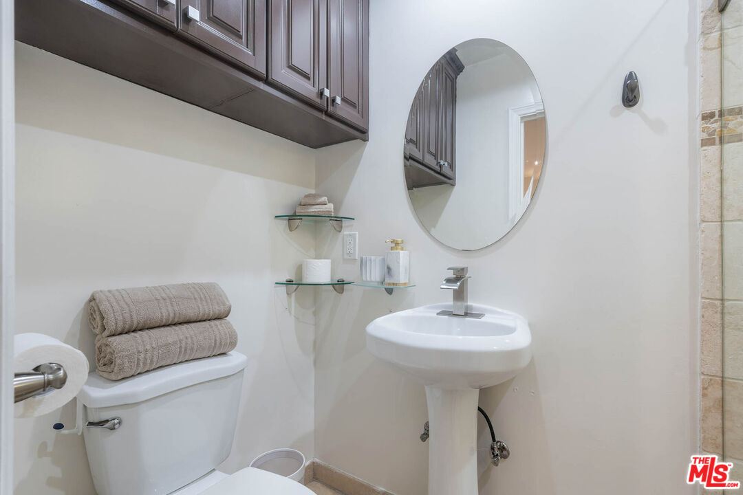 5181 Densmore Avenue Encino, CA 91436 - Photo 22 of 73 a bathroom with a toilet sink and mirror