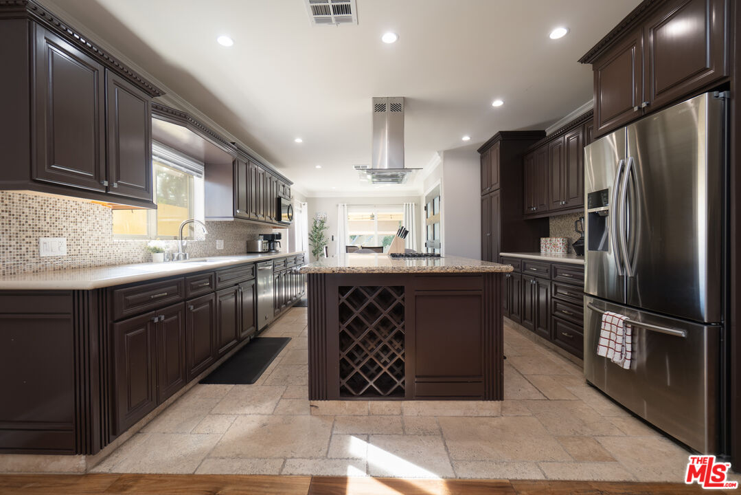 5181 Densmore Avenue Encino, CA 91436 - Photo 42 of 73 a kitchen with stainless steel appliances granite countertop a refrigerator a sink a stove a microwave and cabinets