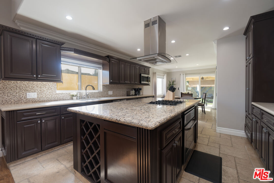 5181 Densmore Avenue Encino, CA 91436 - Photo 43 of 73 a kitchen with kitchen island granite countertop a sink stove and cabinets