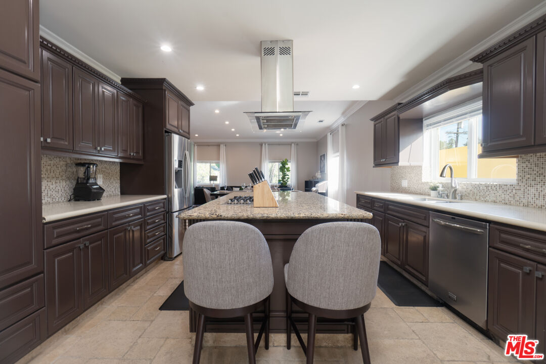 5181 Densmore Avenue Encino, CA 91436 - Photo 44 of 73 a kitchen with kitchen island granite countertop a sink cabinets and window