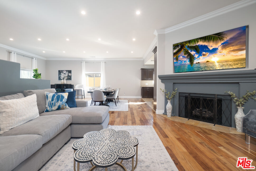 5181 Densmore Avenue Encino, CA 91436 - Photo 5 of 73 a living room with furniture a fireplace and a flat screen tv
