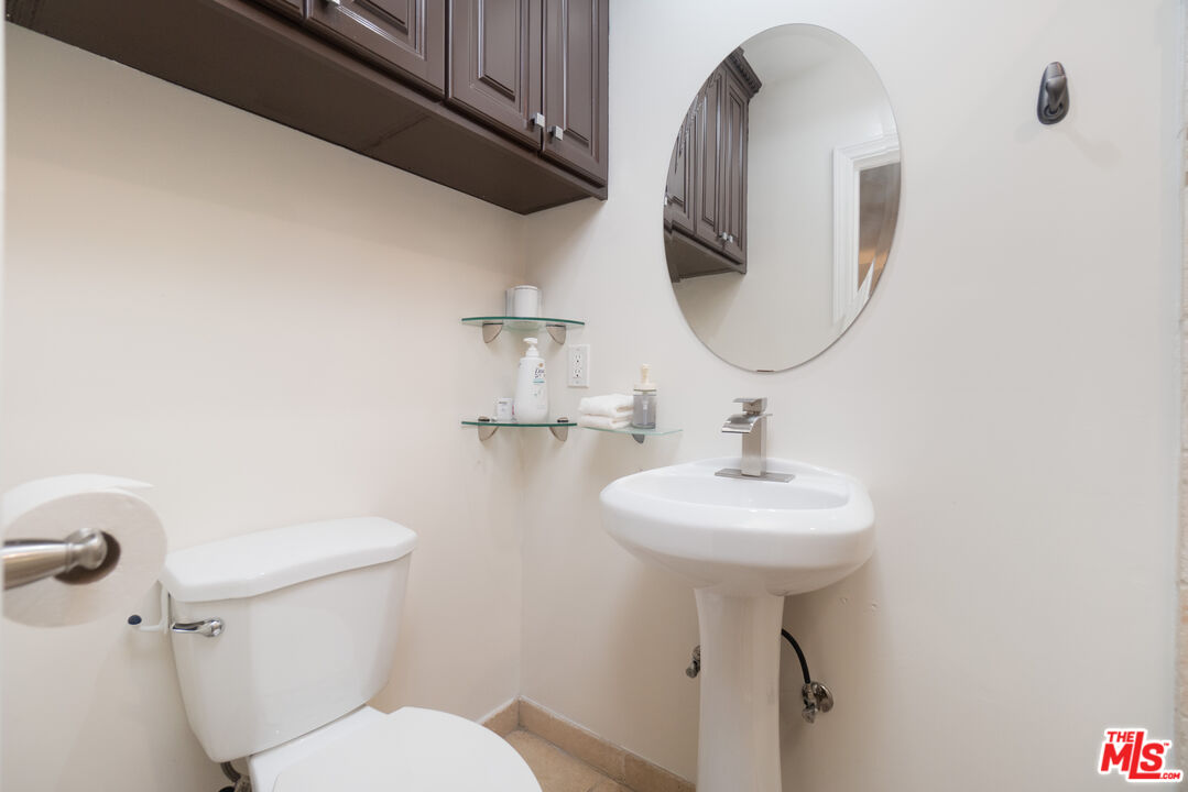 5181 Densmore Avenue Encino, CA 91436 - Photo 57 of 73 a bathroom with a sink a mirror and a toilet