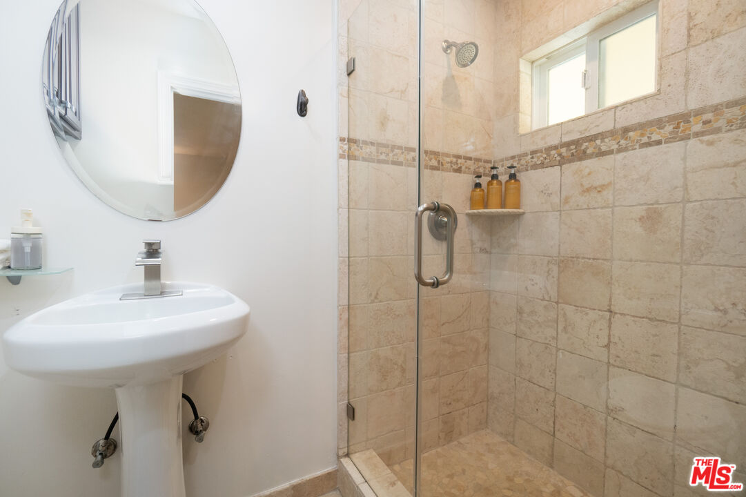 5181 Densmore Avenue Encino, CA 91436 - Photo 58 of 73 a bathroom with a sink a mirror and shower