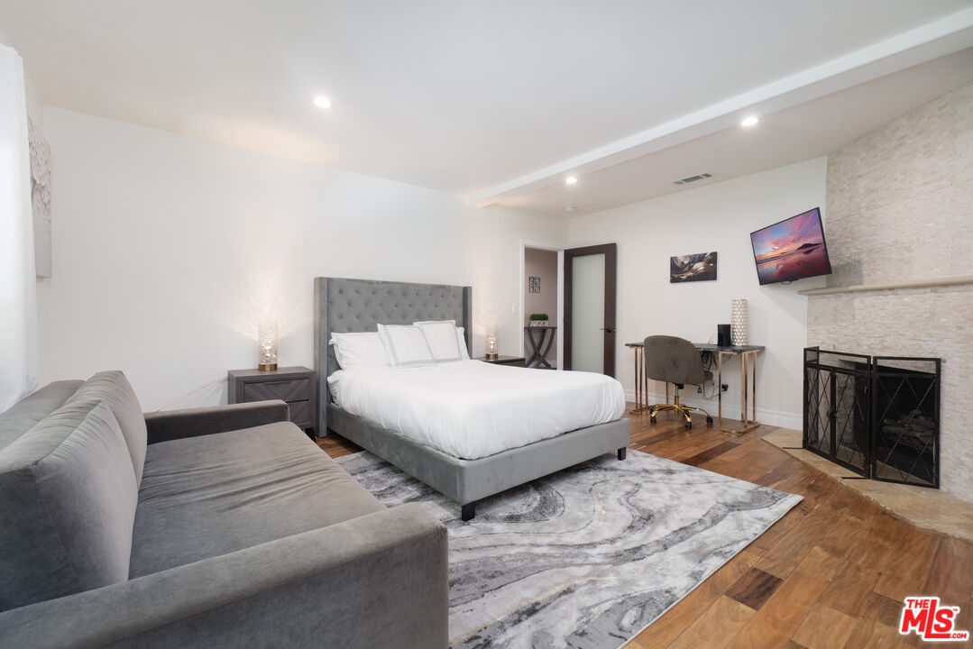 5181 Densmore Avenue Encino, CA 91436 - Photo 59 of 73 a bedroom with a bed and a fireplace