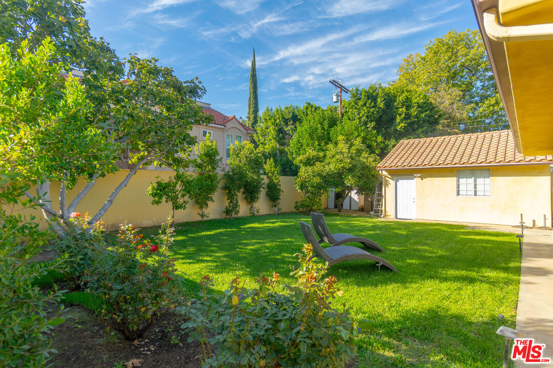 5181 Densmore Avenue Encino, CA 91436 - Photo 72 of 73 a view of a backyard with table and chairs and potted plants