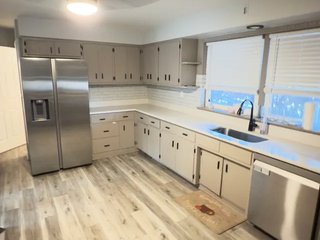 a kitchen with granite countertop a refrigerator and a sink