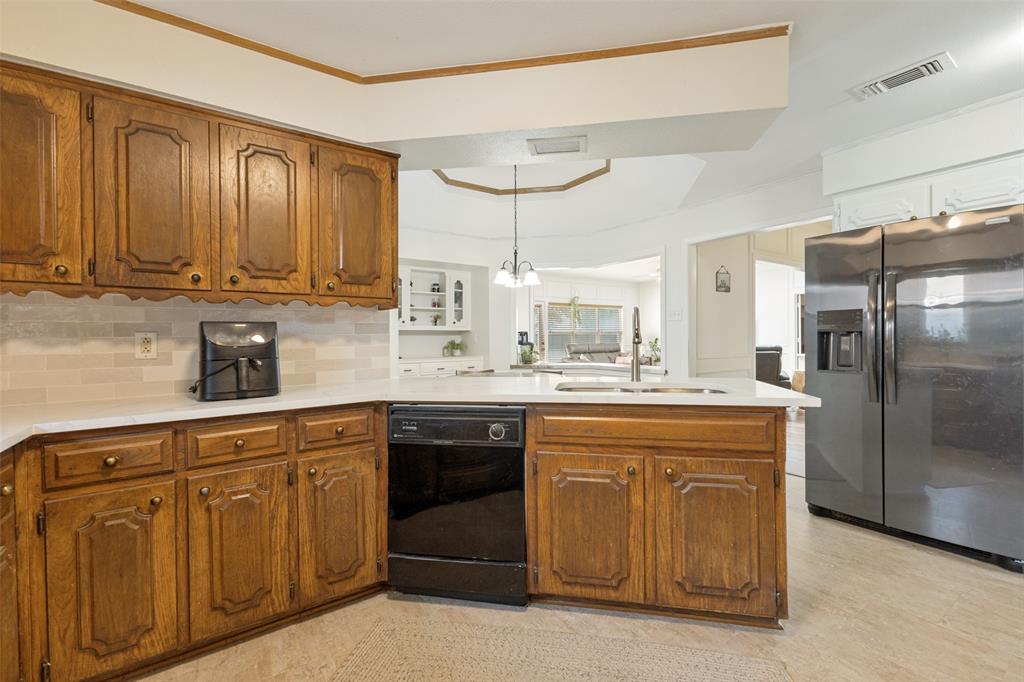 705 South Grove Road Richardson, TX 75081 - Photo 14 of 26 Kitchen featuring wood cabinetry, light countertops, subway tile backsplash, and a stainless steel refrigerator