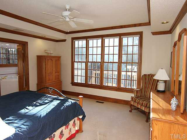 5809 Laurel Rock Lane Raleigh, NC 27613 - Photo 12 of 22 a spacious bedroom with a bed and a chandelier