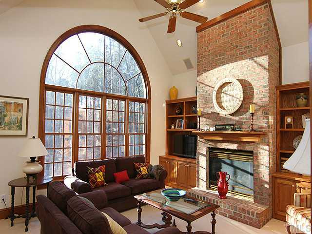 5809 Laurel Rock Lane Raleigh, NC 27613 - Photo 10 of 22 a living room with furniture a fireplace and a large window