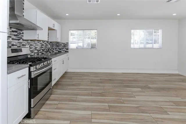 a kitchen with stainless steel appliances granite countertop a stove and a wooden cabinets