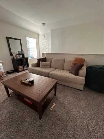 a bedroom with a bed a dresser and a large window