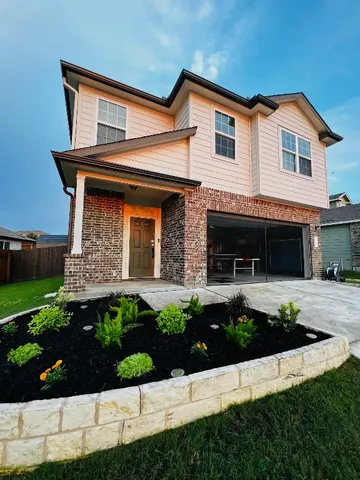 a front view of a house with a garden and plants