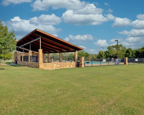 a sign that is sitting in the grass with of trees