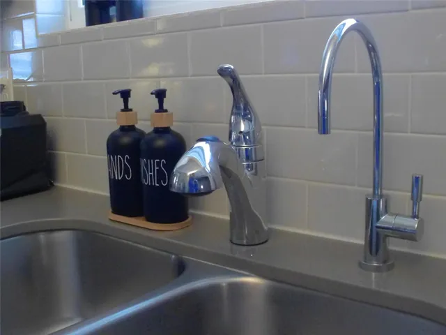 a backyard of a house with table chairs and wooden fence