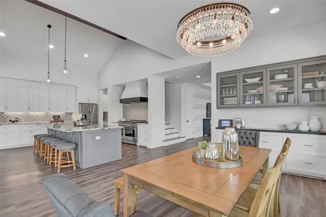 a kitchen with a dining table chairs and view of living room