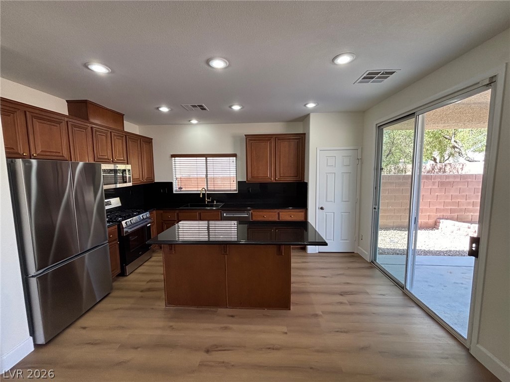 4900 Naff Ridge Drive Las Vegas, NV 89131 - Photo 3 of 21 Culinary creations come alive in this kitchen featuring abundant wood cabinetry and sleek black countertops.