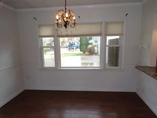 a view of a room with a large window ceiling fan and wooden floor
