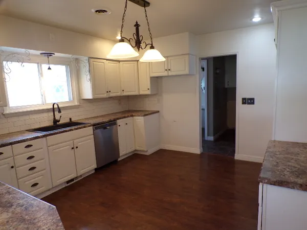 a kitchen with granite countertop a sink cabinets and window