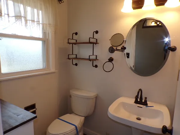 a bathroom with a toilet sink and mirror
