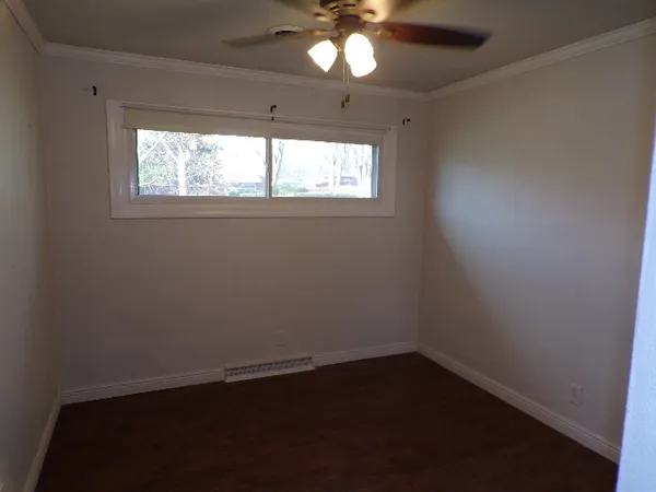 en empty room with window and chandelier fan