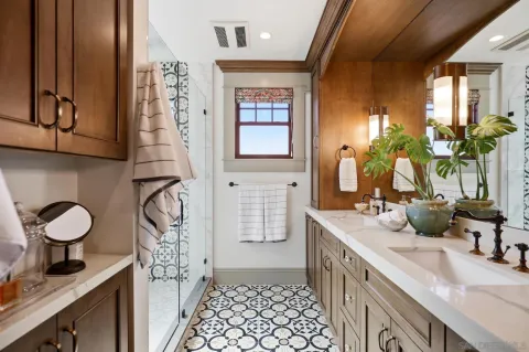 a bathroom with double vanity and a mirror