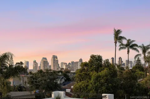 a view of a city from a roof deck with furniture