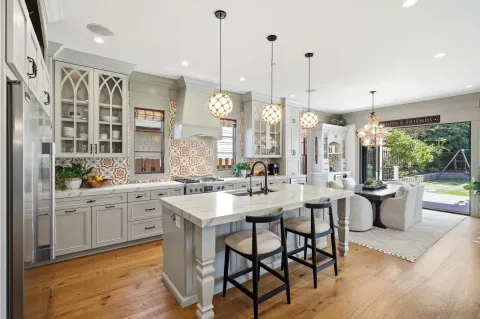 a kitchen with a chandelier a dining table and chairs