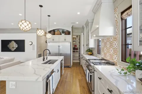 a large kitchen with stainless steel appliances kitchen island granite countertop a large kitchen island a stove and a view of living room