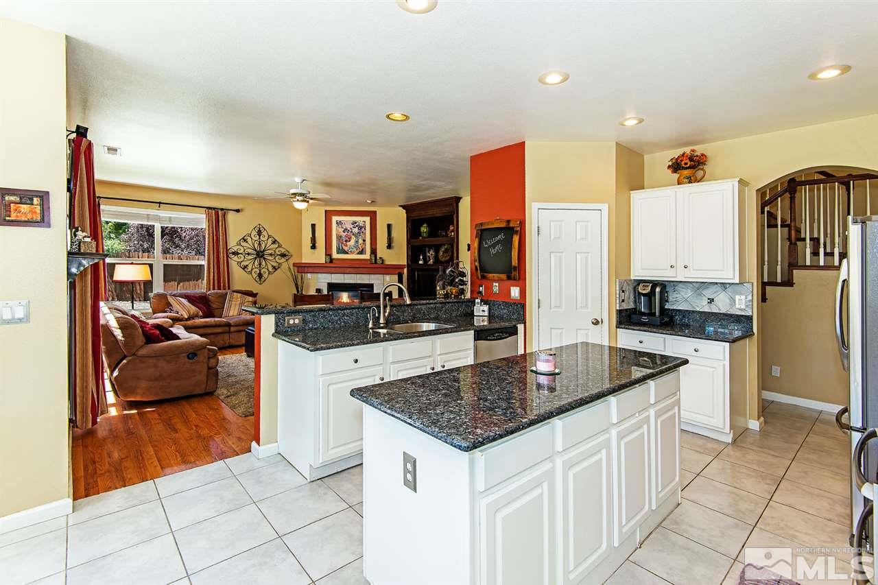 9765 Lemke Court Reno, NV 89521 - Photo 8 of 22 a kitchen with stainless steel appliances granite countertop a sink and a refrigerator