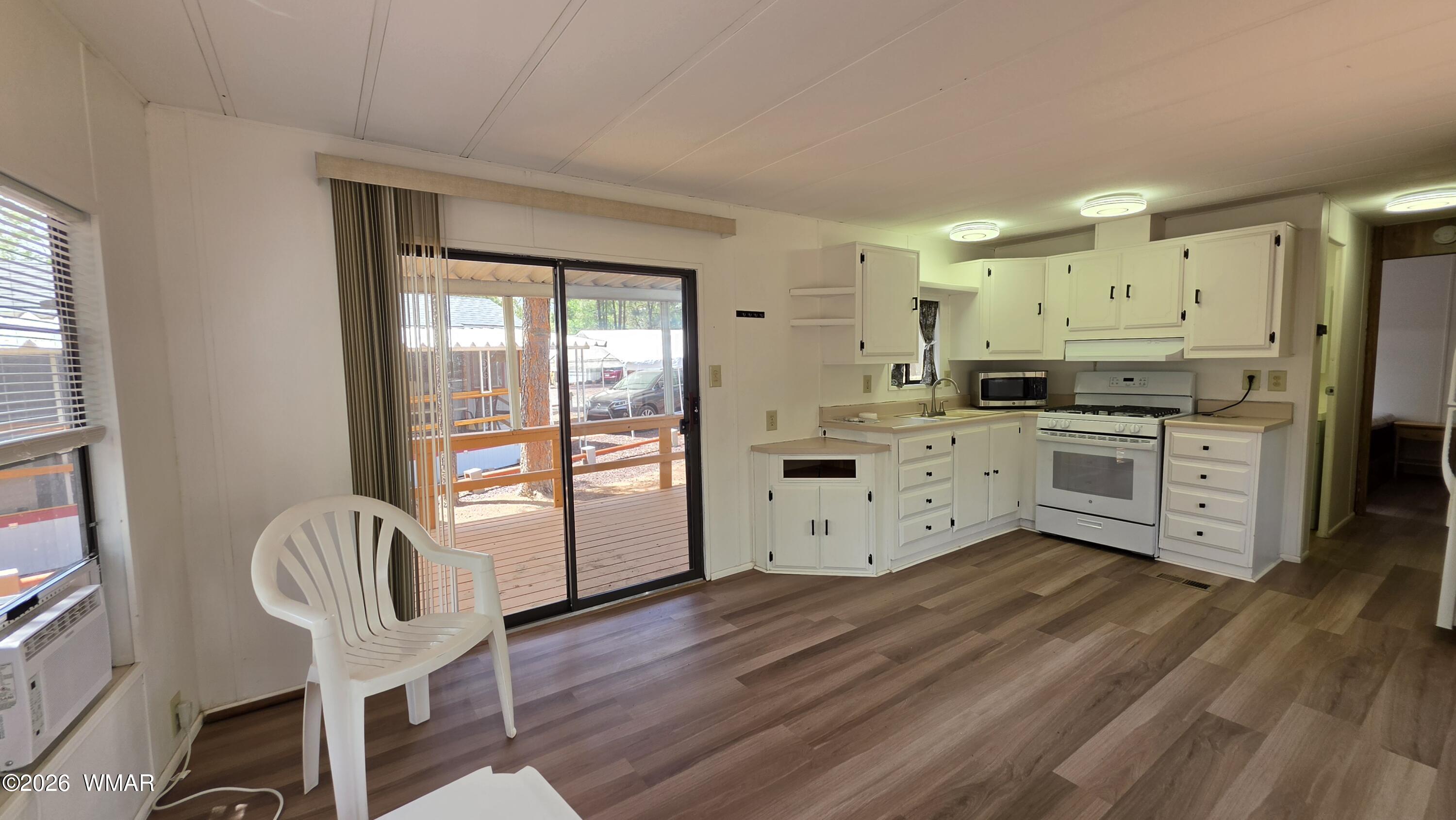 2468 Running Bear Road, Unit 44 Lakeside, AZ 85929 - Photo 5 of 11 a kitchen with stainless steel appliances granite countertop a stove top oven a sink dishwasher and white cabinets with wooden floor