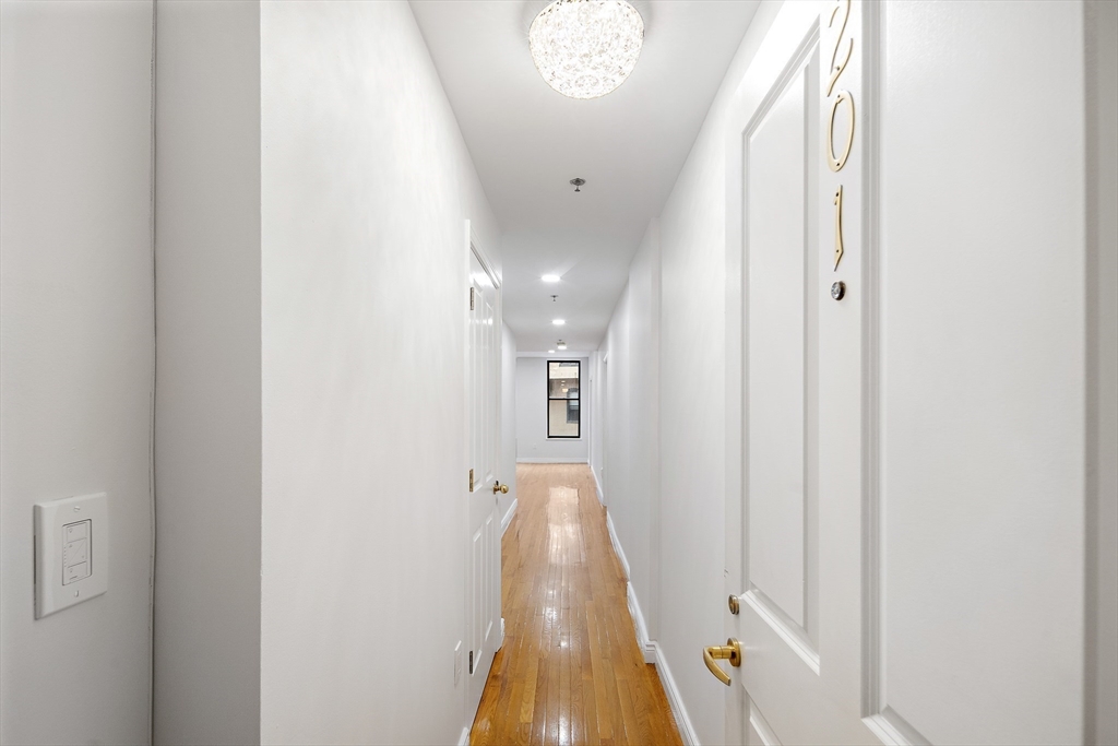 4 Charlesgate East, Unit 201 Boston, MA 02215 - Photo 17 of 32 a view of a hallway with wooden floor and a chandelier