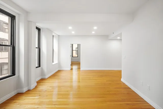 a view of an empty room with wooden floor