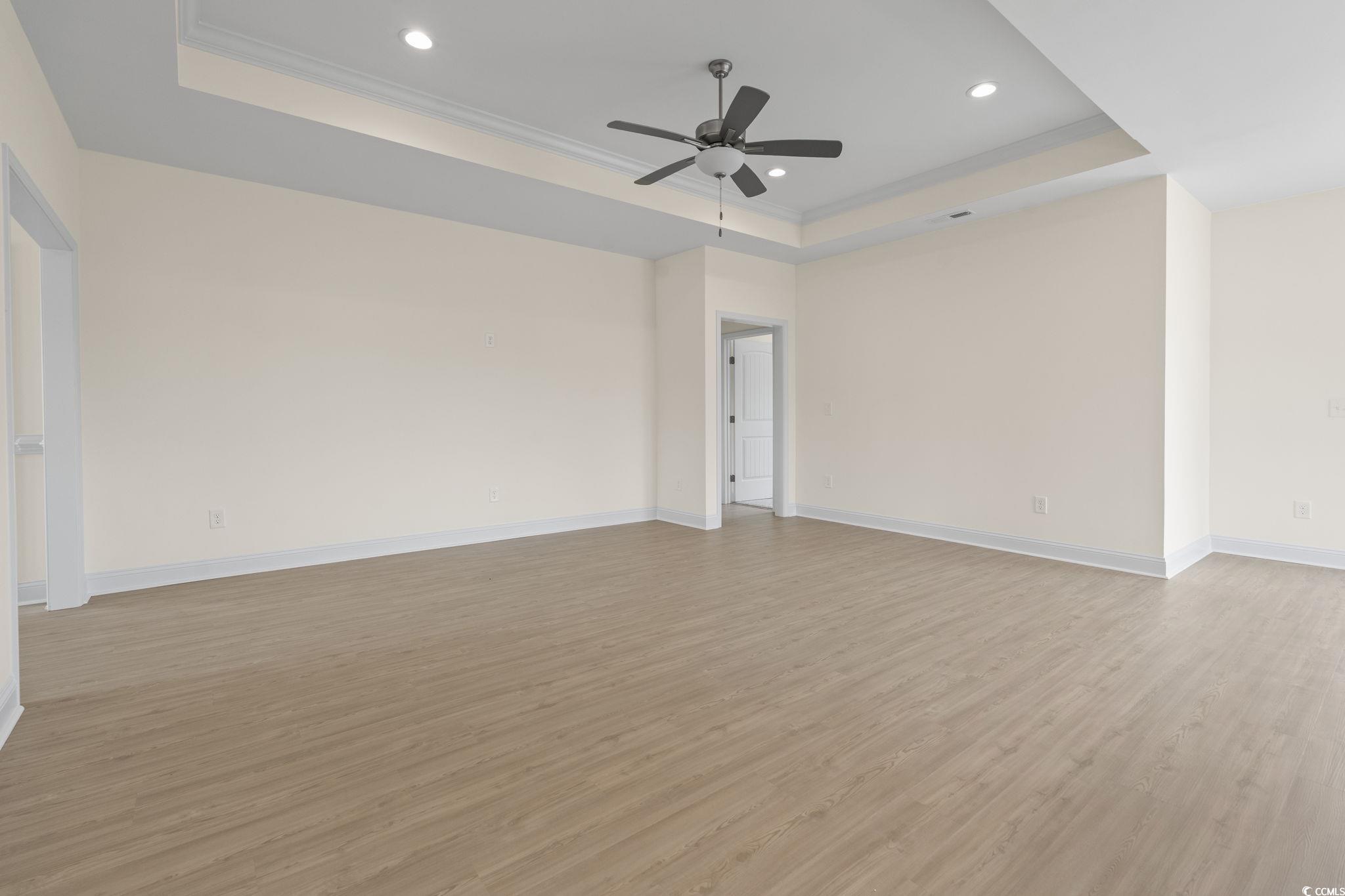 108 Infinity Lane Loris, SC 29569 - Photo 10 of 35 Living Room featuring a raised ceiling, light wood