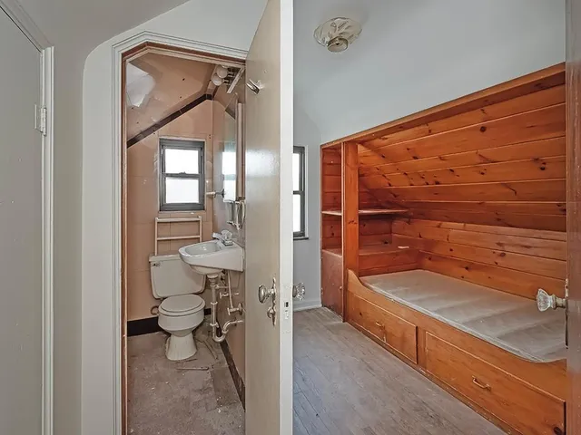a bathroom with a toilet a sink and mirror