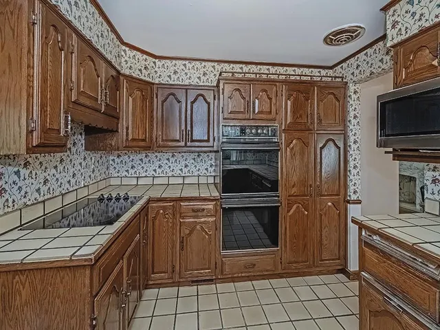 a kitchen with stainless steel appliances granite countertop a stove a sink and a microwave