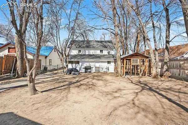a view of a building with trees covered with snow in front of house