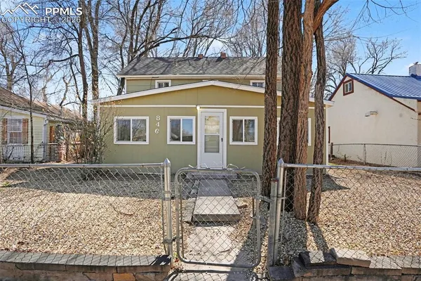 a view of a brick house with a large tree