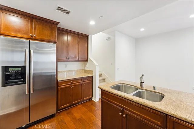 a kitchen with stainless steel appliances granite countertop a refrigerator a sink and a stove