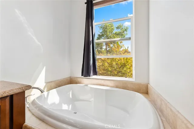 a white bath tub sitting in a bathroom next to a window