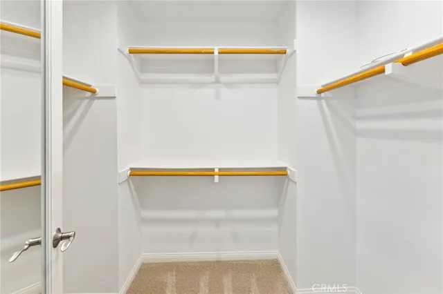 a view of walk in closet with empty racks
