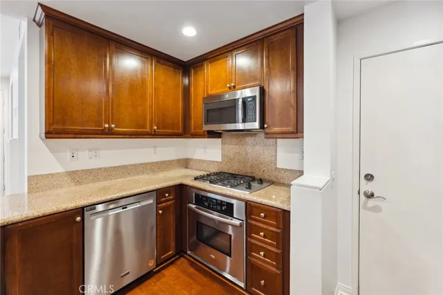 a kitchen with stainless steel appliances granite countertop cabinets and a stove top oven