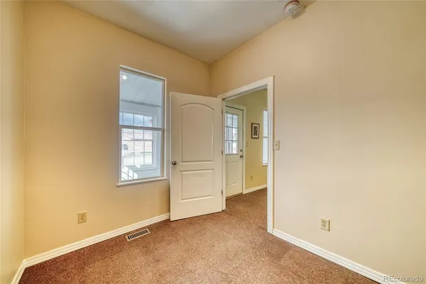 an empty room with windows and closet