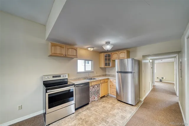 a kitchen with a refrigerator and a stove top oven