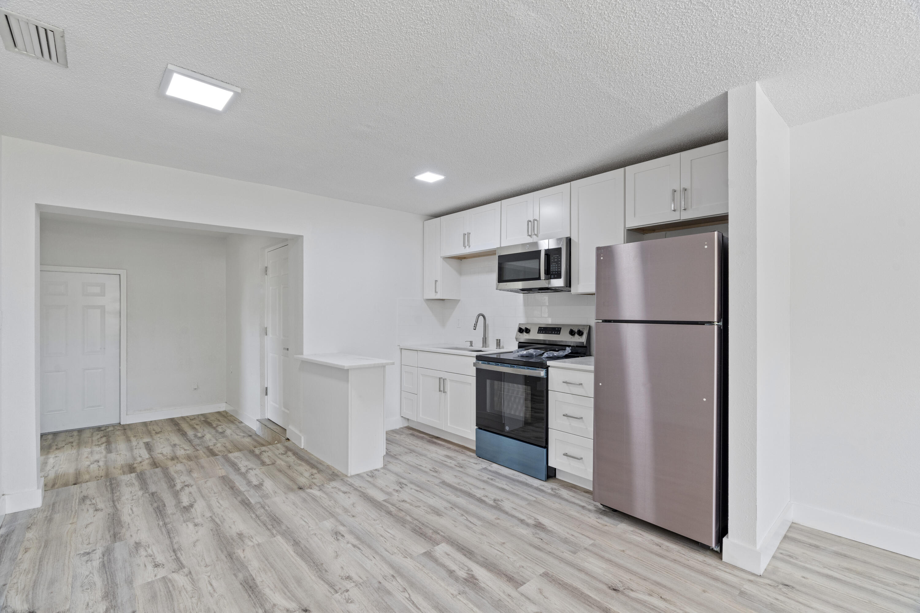662 Granada Street Fort Pierce, FL 34949 - Photo 12 of 48 a kitchen with granite countertop a refrigerator stove and wooden floor